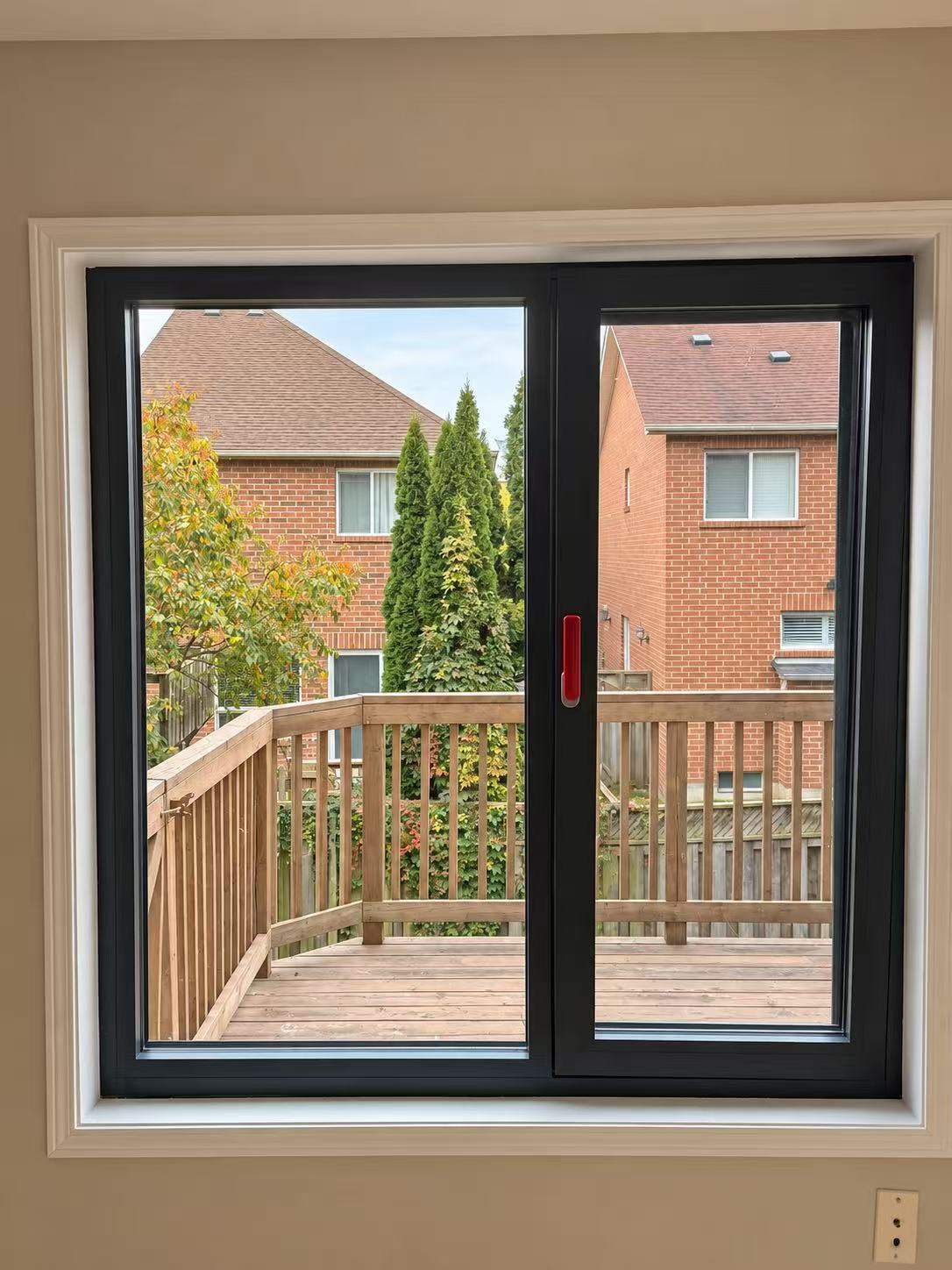 Dark-framed window overlooking a wooden deck.